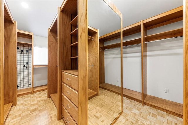 walk in closet with light parquet flooring