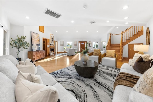 living room featuring lofted ceiling and light wood-type flooring