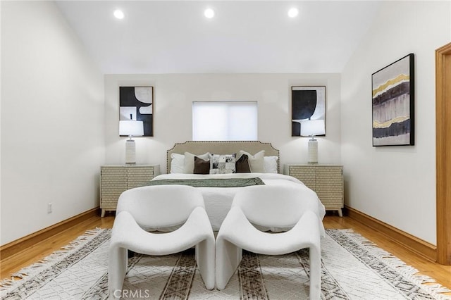 bedroom with vaulted ceiling and hardwood / wood-style floors