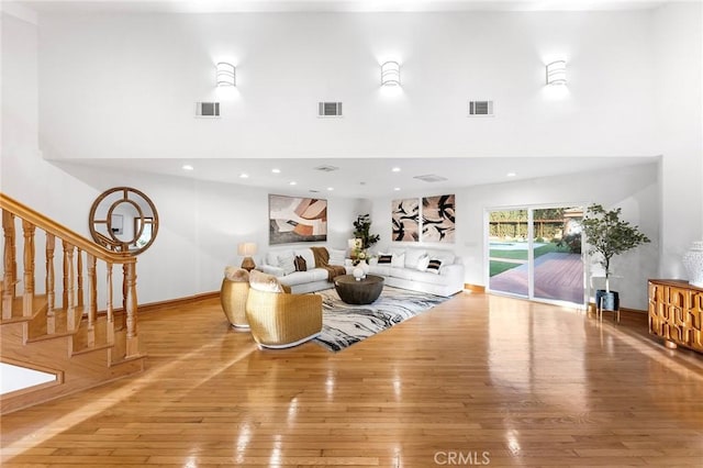 living room with a high ceiling and light hardwood / wood-style floors