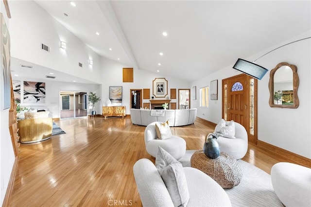 living room with light hardwood / wood-style flooring and high vaulted ceiling