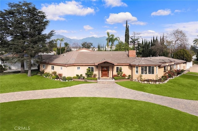 single story home with a mountain view and a front yard