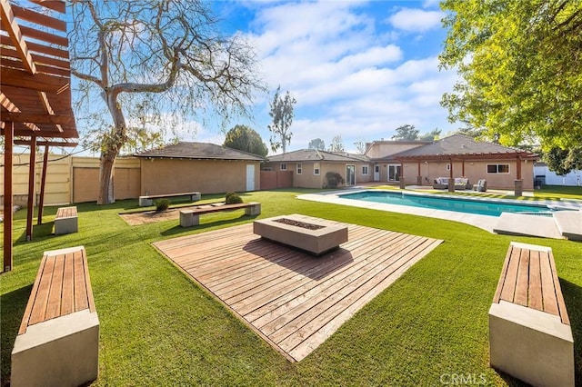 view of swimming pool with a pergola, a yard, and an outdoor fire pit