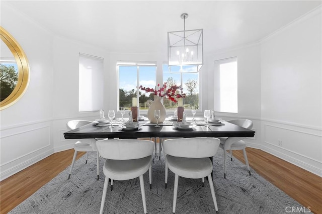 dining room featuring hardwood / wood-style flooring, ornamental molding, and a chandelier