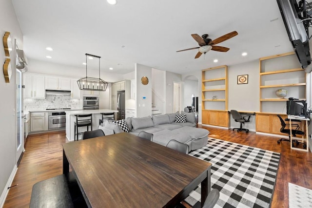 dining room with dark hardwood / wood-style floors, built in desk, and ceiling fan