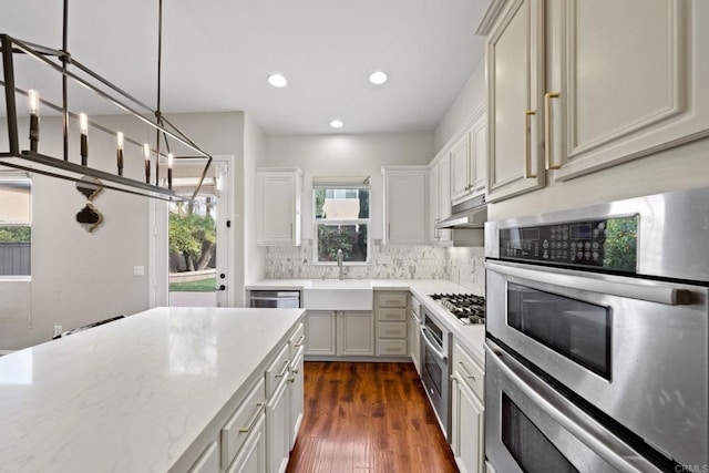 kitchen featuring sink, decorative light fixtures, a healthy amount of sunlight, and appliances with stainless steel finishes