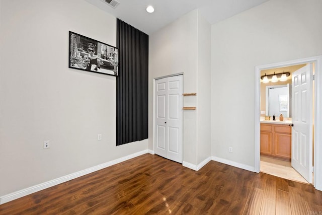 interior space featuring sink, dark wood-type flooring, connected bathroom, and a closet