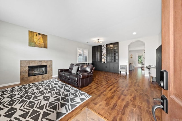 living room featuring a tiled fireplace and hardwood / wood-style flooring