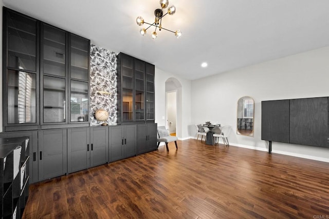 bar with dark wood-type flooring and a chandelier