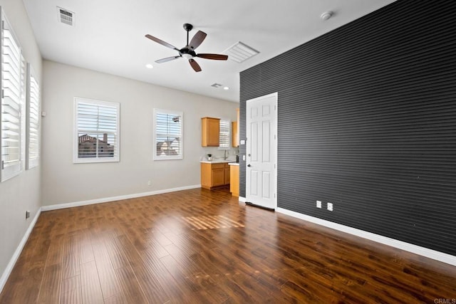 interior space with dark wood-type flooring and ceiling fan