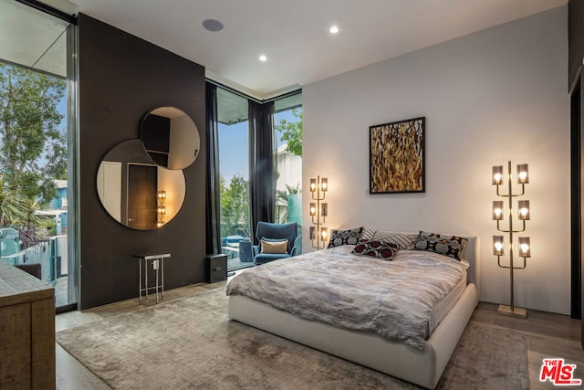 bedroom featuring expansive windows, access to exterior, and multiple windows