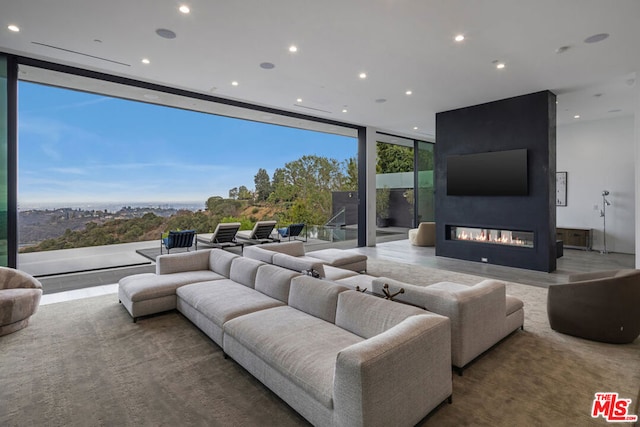 living room featuring a large fireplace and a wall of windows