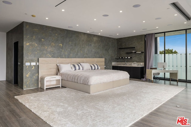 bedroom featuring a wall of windows and dark hardwood / wood-style floors