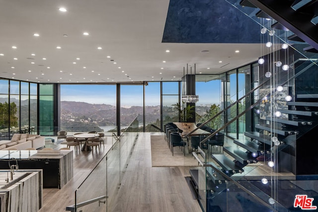 interior space with expansive windows, a mountain view, and light wood-type flooring