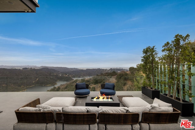 view of patio featuring a water and mountain view and an outdoor fire pit