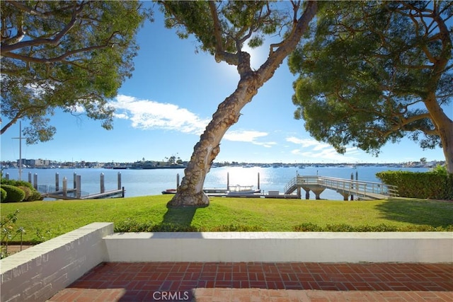 view of yard featuring a water view and a dock