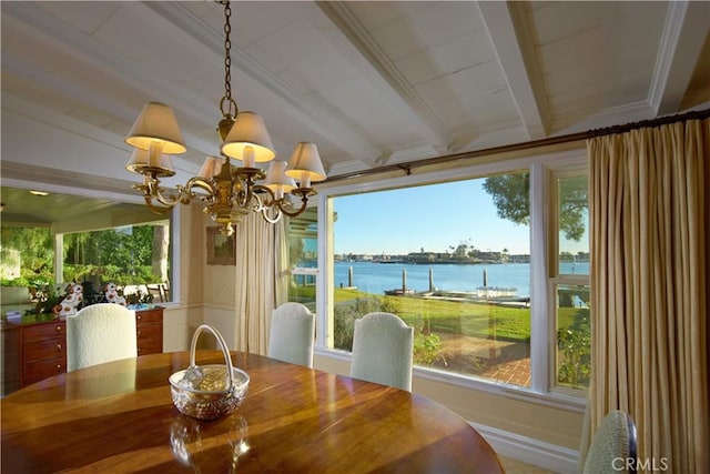 dining area featuring an inviting chandelier, beam ceiling, and a water view