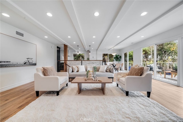 living room featuring light wood-type flooring and beam ceiling