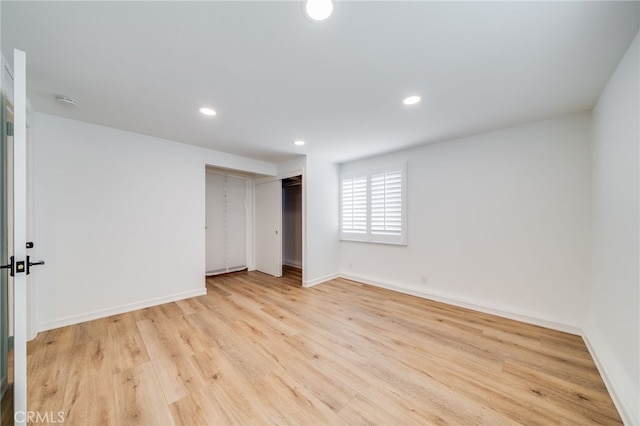 unfurnished bedroom with light hardwood / wood-style flooring and a closet