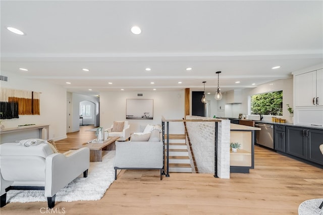 living room with beamed ceiling and light wood-type flooring