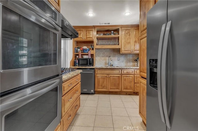 kitchen featuring light stone counters, stainless steel appliances, open shelves, a sink, and light tile patterned flooring