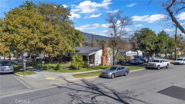 view of street with curbs, sidewalks, and a mountain view