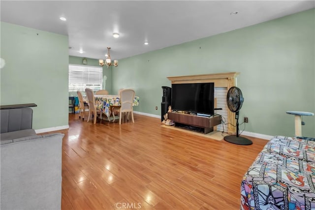 living area with a chandelier, recessed lighting, wood finished floors, and baseboards