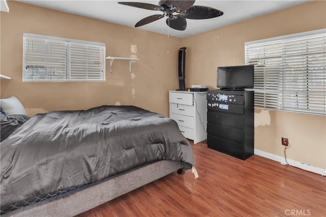 bedroom with light wood-style flooring, baseboards, and ceiling fan