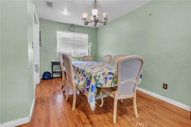 dining space featuring a chandelier, visible vents, light wood-style flooring, and baseboards