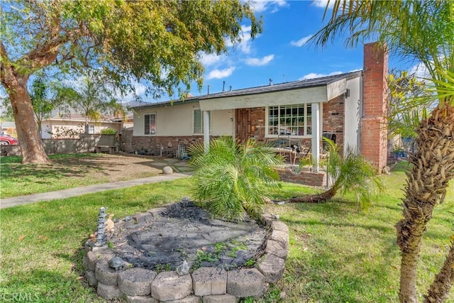 ranch-style house featuring a chimney, stucco siding, fence, stone siding, and a front lawn