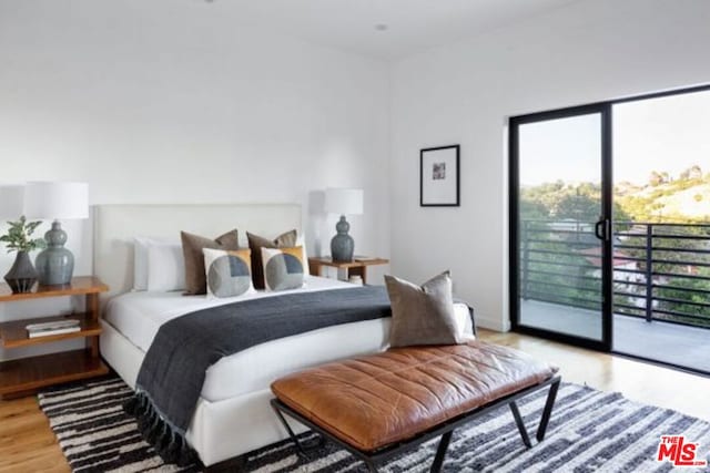 bedroom with access to exterior and light wood-type flooring