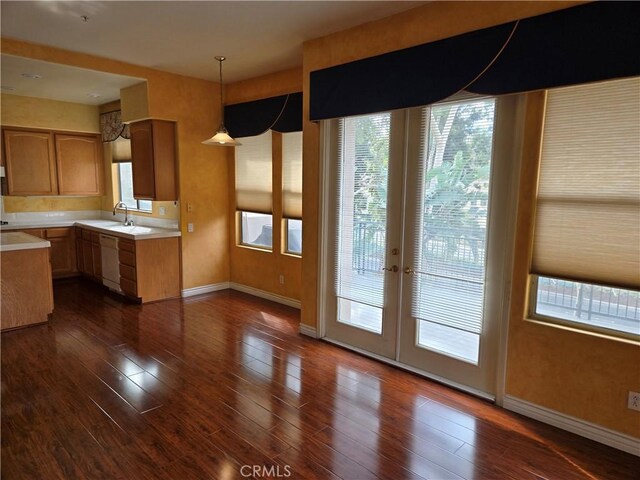 kitchen featuring pendant lighting, dark wood-type flooring, and dishwasher