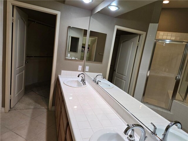 bathroom featuring vanity, a shower with shower door, and tile patterned floors