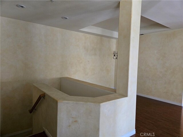 interior space featuring hardwood / wood-style flooring and a raised ceiling