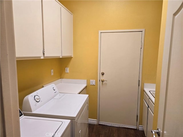 laundry room featuring dark hardwood / wood-style flooring, washing machine and dryer, and cabinets