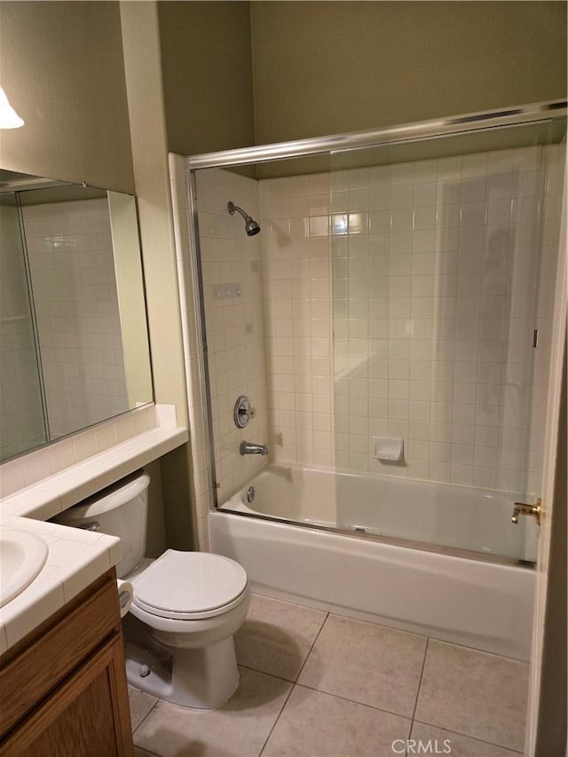 full bathroom featuring tile patterned flooring, vanity, tiled shower / bath combo, and toilet