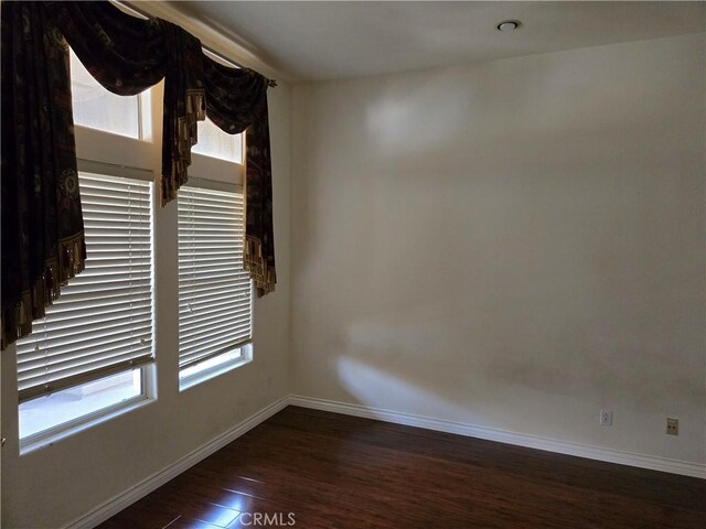 unfurnished room with dark wood-type flooring