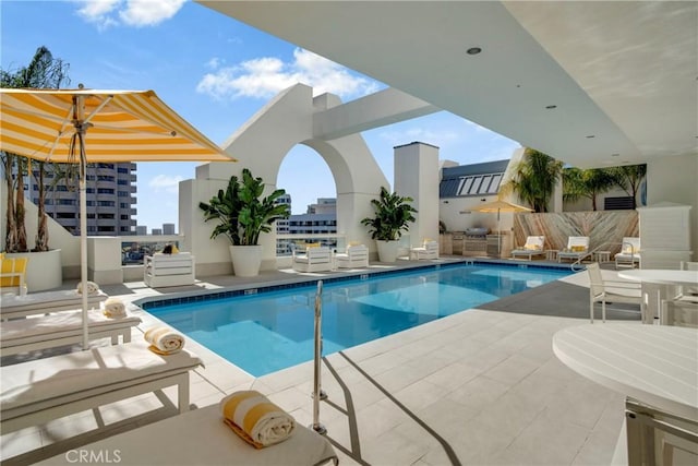 view of pool featuring area for grilling and a patio