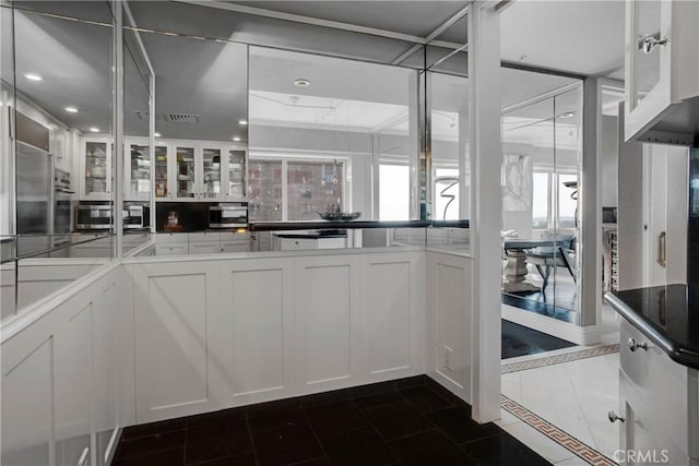 kitchen featuring white cabinetry and dark tile patterned floors