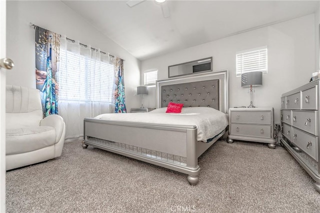 carpeted bedroom with vaulted ceiling and ceiling fan