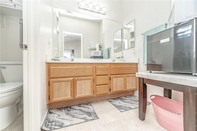 bathroom with vanity, tile patterned floors, and toilet