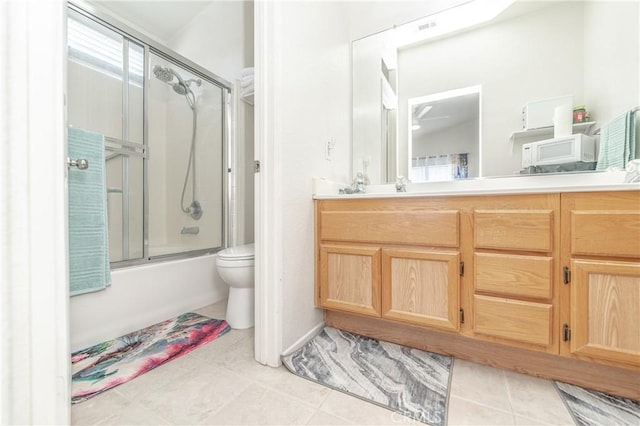 full bathroom with vanity, combined bath / shower with glass door, tile patterned floors, and toilet