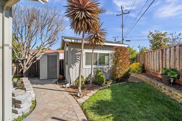 view of side of home with a yard and a shed