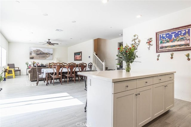 kitchen featuring ceiling fan, a center island, light hardwood / wood-style floors, and cream cabinetry