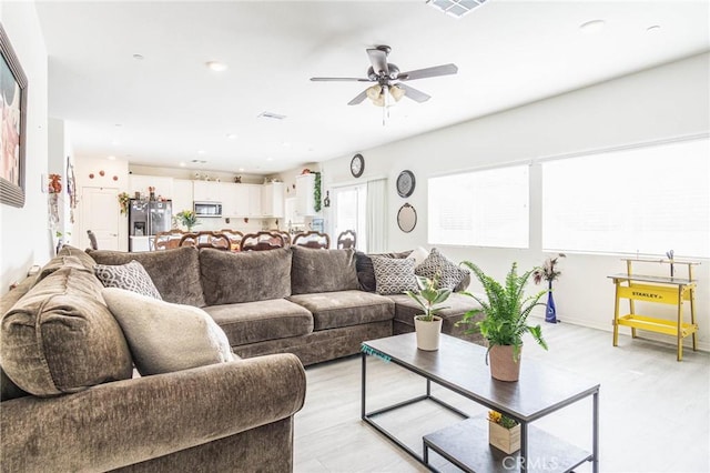 living room featuring ceiling fan and light hardwood / wood-style flooring