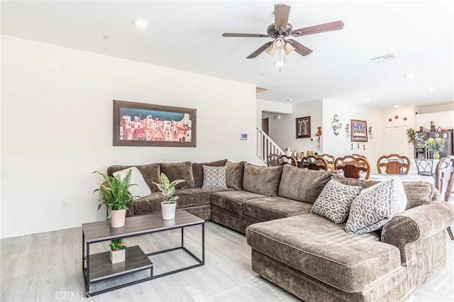 living room featuring light hardwood / wood-style flooring and ceiling fan