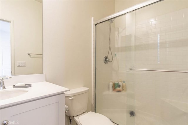 bathroom with vanity, a shower with shower door, and toilet