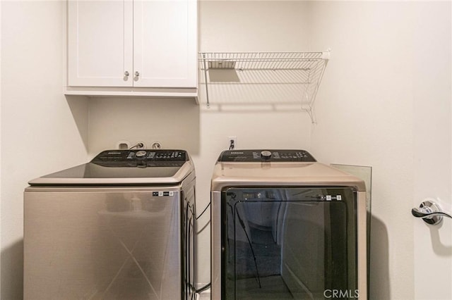 washroom featuring cabinets and washing machine and clothes dryer