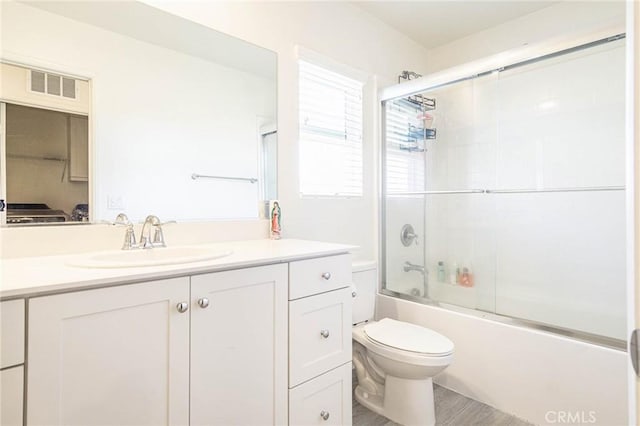 full bathroom featuring enclosed tub / shower combo, vanity, toilet, and hardwood / wood-style floors