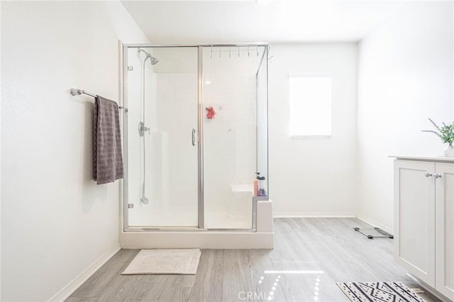 bathroom with wood-type flooring and an enclosed shower